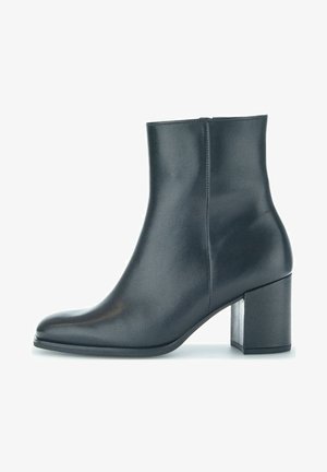 Bottine en cuir noir avec bout rond et talon carré, finition lisse, fermeture éclair latérale, sur fond blanc uni.