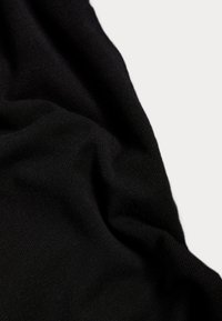 Tessuto nero lavorato a maglia con una consistenza morbida, caratterizzato da un aspetto leggermente stropicciato e una trama liscia e uniforme.