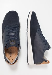 Sneaker blu navy realizzati in suède e pelle, con una tomaia testurizzata, occhielli rotondi e una suola bianca con scanalature antiscivolo.