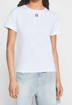 Hvid T-shirt med kortærmer og rund halsudskæring, med et sort "HUGO" logo på brystet. Fremstillet af blødt, glat stof.
