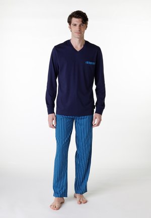 Maglietta a maniche lunghe blu marinara con scollo a V e taschino sul petto; pantaloni da pigiama a strisce blu con vestibilità rilassata. Materiale in cotone, leggero e comodo.