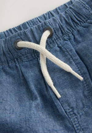 Világoskék farmer rövidnadrág, rugalmas derékkal, fehér zsinórral és fekete szellőzőlyukakkal. Az anyag sima tapintású és finom szövésű.