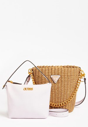 Kaksi Guessin käsilaukkua: pieni valkoinen nahkainen olkalaukku kultaisella logolla ja suurempi punottu olkilaukku kultaisella ketjuhihnalla ja logolla.