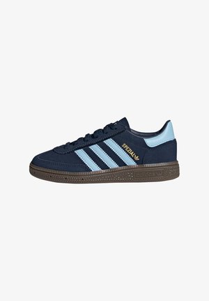 Zapatilla Adidas Spezial azul marino con rayas azul claro, lengüeta del talón azul claro, cordones negros y suela marrón texturizada.