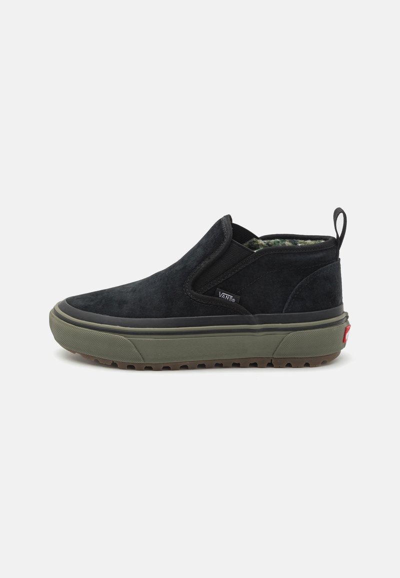 Schwarzer Slip-On-Schuh aus Wildleder mit grüner Gummisohle, strukturiertem Obermaterial, elastischen Seiteneinsätzen und kleinem hinteren Zugband.