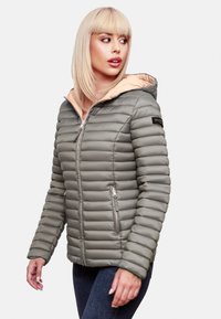 Lättviktsgrå pufferjacka med en ljusbeige huva, kviltad textur, dragkedja framtill och två sidfickor. Varumärkeslogotyp på ärmen.