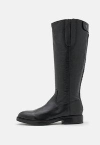 Botte noire en cuir, haute jusqu'au genou, avec un petit talon, un bout arrondi lisse, des coutures latérales et une languette avec un bouton décoratif en haut.