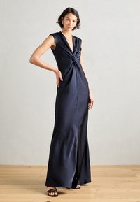Sinine satiin kleit, millel on sügav V-kaelus, keerutamise detail vööl ja külgslits. Sujuv tekstuur ning põrandani ulatuv siluett.
