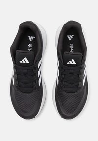 Paire de chaussures de course athlétiques noires et blanches avec tiges en mesh et semelles intérieures de marque vues de dessus sur fond blanc.