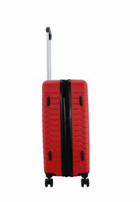 Valigia rigida rossa con superficie strutturata, manico retrattile, zip nera e quattro ruote per una facile mobilità.