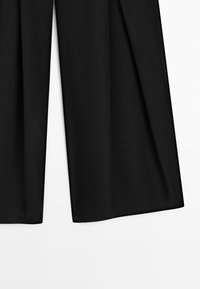 Pantaloni neri a gamba larga con orlo dritto, mostrati su uno sfondo bianco semplice.
