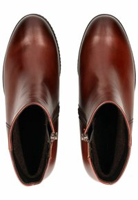 Bottes de cheville en cuir brun avec une finition lisse, fermeture éclair sur le côté et doublure intérieure texturée. Bout rond et petit talon.