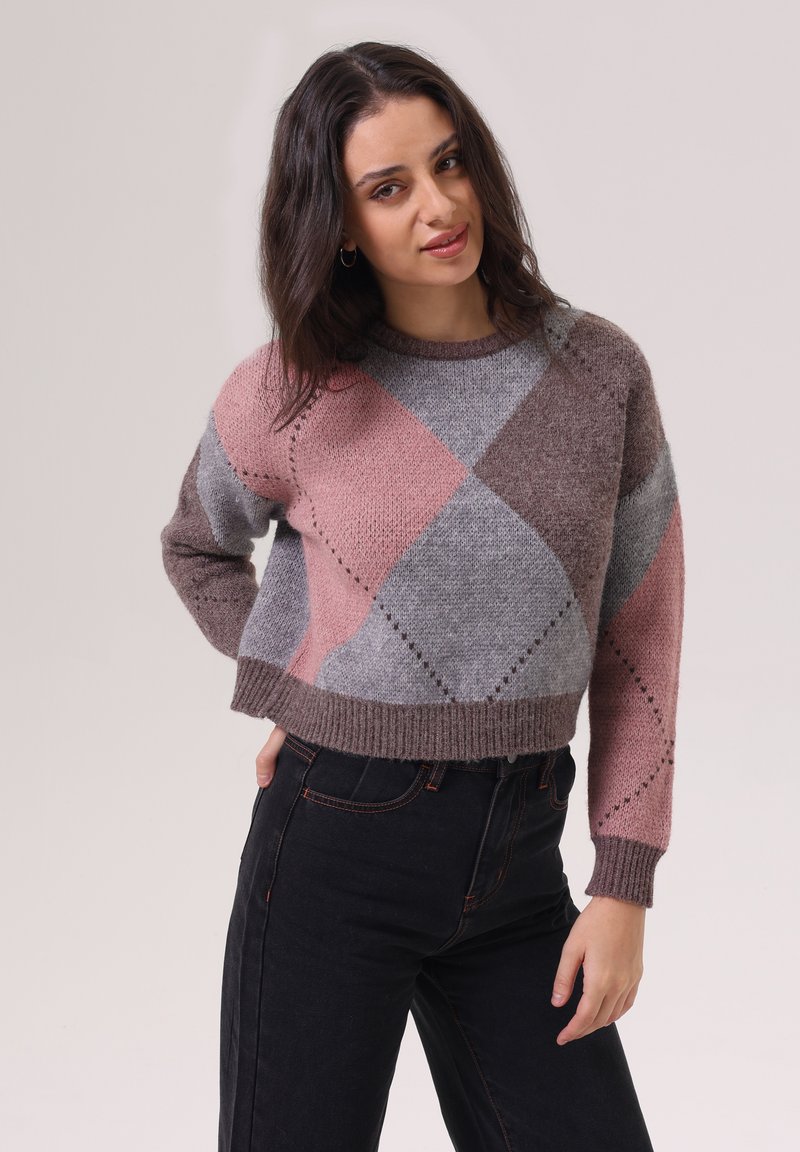 Pull en argyle gris, rose et marron avec un ourlet et des poignets côtelés, fabriqué en tissu tricoté. Stylé avec un jean noir taille haute.