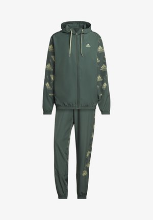 Grøn Adidas træningsdragt med hættetrøje med lynlås og matchende bukser, der har logomønstre på ærmerne og buksernes sider.