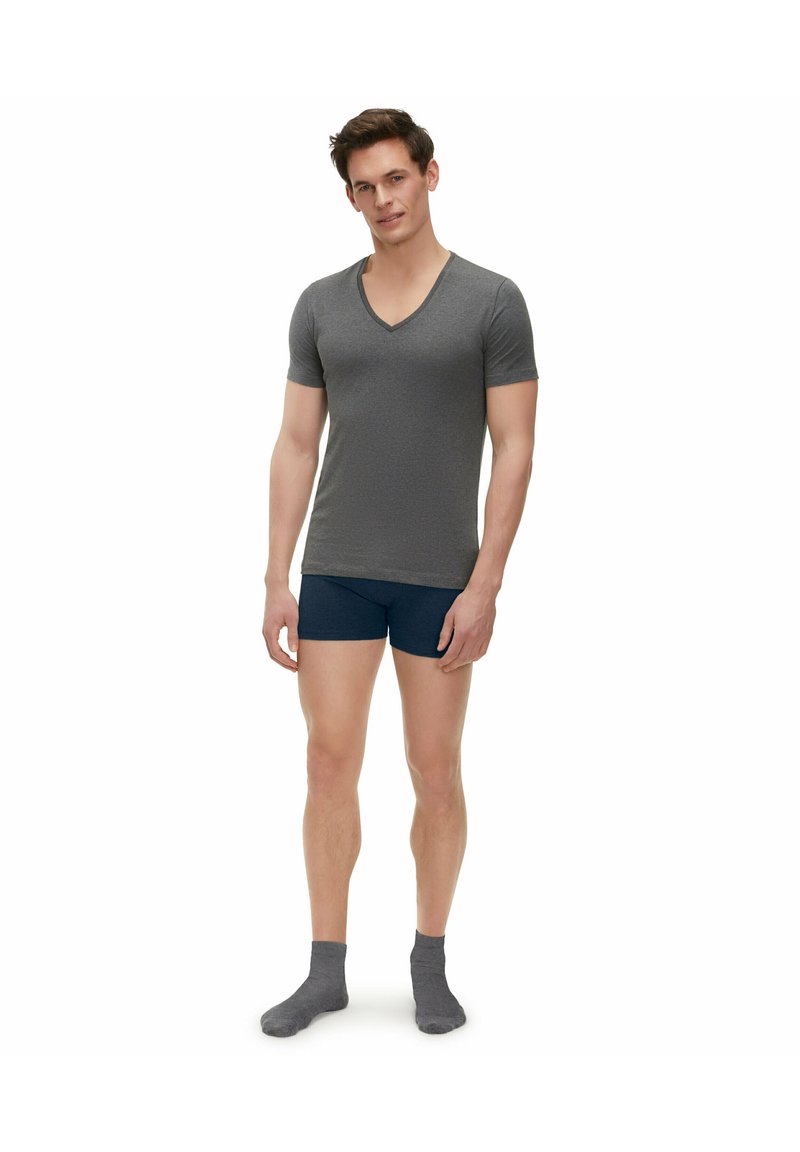 Maglietta grigia a maniche corte con scollo a V, boxer blu navy e calzini grigi. La maglietta presenta una trama sottile e un design aderente.