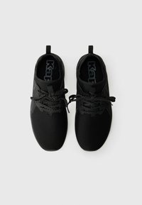 Baskets de sport noires avec un dessus en maille, bout rond, semelle plate et lacets réfléchissants. Dotées d'une languette à l'arrière pour un enfilage facile.
