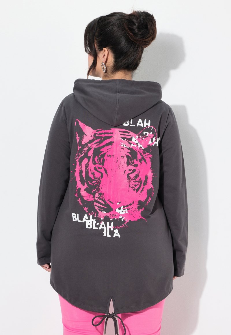 Felpa grigia con cappuccio caratterizzata da una grande grafica di una tigre rosa e testo bianco sul retro. Leggera, con orlo arrotondato e lacci regolabili.