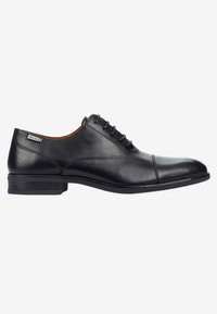 Zapato de vestir negro de cuero con un acabado suave, diseño de cordones, punta redonda, detalles de costura sutiles y un tacón bajo apilado.