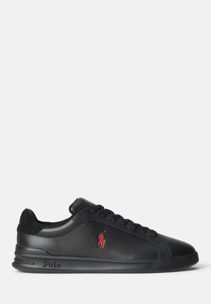 Czarny skórzany sneaker z czarnymi sznurowadłami, czerwonym logo Polo po boku oraz napisem „Polo” wytłoczonym na podeszwie, widziany od zewnętrznej strony.