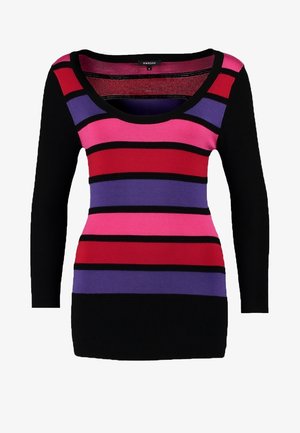 Stribet sweater med sorte, røde, lilla og pink vandrette striber; slim-fit blå jeans; bærer en grå clutch; iført sorte ankelstøvler.