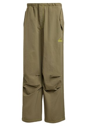 Pantalon Adidas de couleur kaki avec taille élastique, poches latérales, jambes droites et larges, et petit logo Adidas jaune néon sur la cuisse droite.