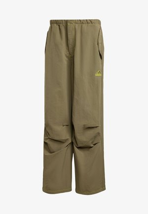 Pantalon Adidas de couleur kaki avec taille élastique, poches latérales, jambes droites et larges, et petit logo Adidas jaune néon sur la cuisse droite.