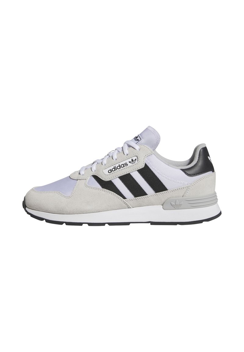 Adidași din suede gri deschis și plasă, cu dungi negre, talpă albă, design cu șireturi și accente cu logo pe limbă și călcâi.