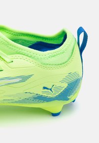 Crampons de football jaune fluo avec une surface texturée, des accents bleus et un design à tige basse. Comprend un onglet de talon robuste et un logo bien en évidence.