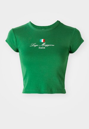 Zeleni kratki majica izrađena od mekanog pamučnog materijala. Ima kratke rukave i vez "Lago Maggiore Italia" s malom zastavom iznad.