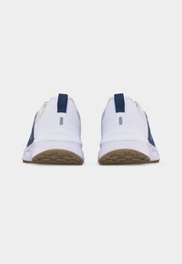 Ζευγάρι λευκών και ναυτικών παπουτσιών για τρέξιμο εμφανίζεται από πίσω με καφέ υφασμένα πέλματα και ναυτικά πίσω τμηματικά κράτησης σε λευκό φόντο.