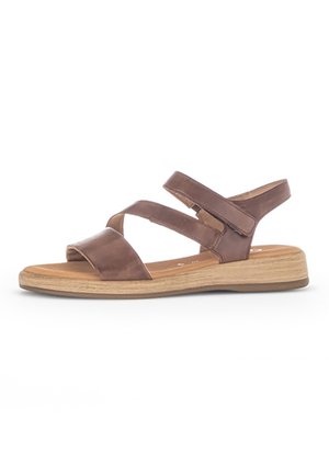 Ruske nahkaste sandale s številnimi prečnimi trakovi, odprtimi prsti in svetlim lesenim podplatom. Oblikovanje se ponaša z minimalističnim, sproščenim slogom.