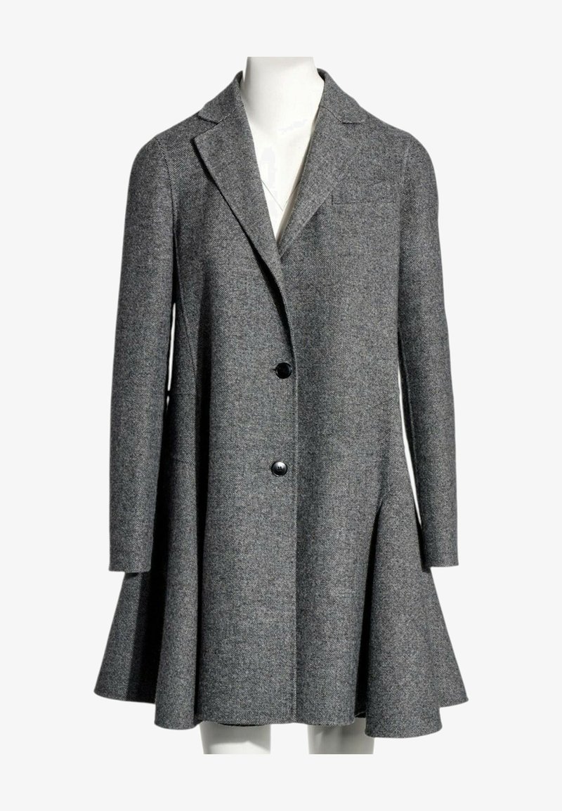 Long manteau gris en laine avec un large ourlet évasé, deux boutons sur le devant, col à revers cranté et manches longues présenté sur un mannequin.