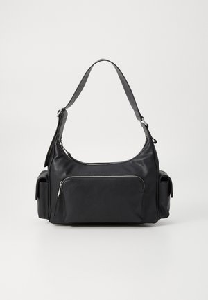 Mustast nahast õlakott ümarate vormide ja tõmblukuga esikotiga, samuti kahe külgetaskuga. Omab ühte reguleeritavat rihma.