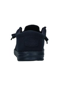 Zapatos slip-on en azul marino con una parte superior de tela suave, superficie texturizada y una lengüeta en la parte trasera. Cuentan con una suela de goma para mayor agarre.
