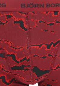 Rood en zwart gestreepte boxershorts met een zachte textuur, voorzien van een zwarte elastische tailleband met het "BJÖRN BORG" logo. Kenmerkend zigzag ontwerp.