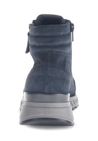 Botín de ante azul oscuro con un empeine texturizado, collar acolchado, cremallera lateral y una suela gris en contraste. Presenta un diseño minimalista.