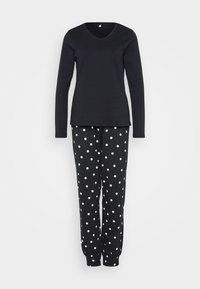 Top negru cu mânecă lungă și decolteu în V, combinat cu pantaloni negri cu buline albe. Pantalonii au manșete elastice, iar ambele articole sunt fabricate dintr-un material moale.