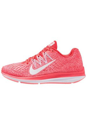 Chaussure de course Nike rose corail avec logo swoosh blanc, tige en mesh léger, semelle rembourrée et lacets roses, montrée de profil latéral.