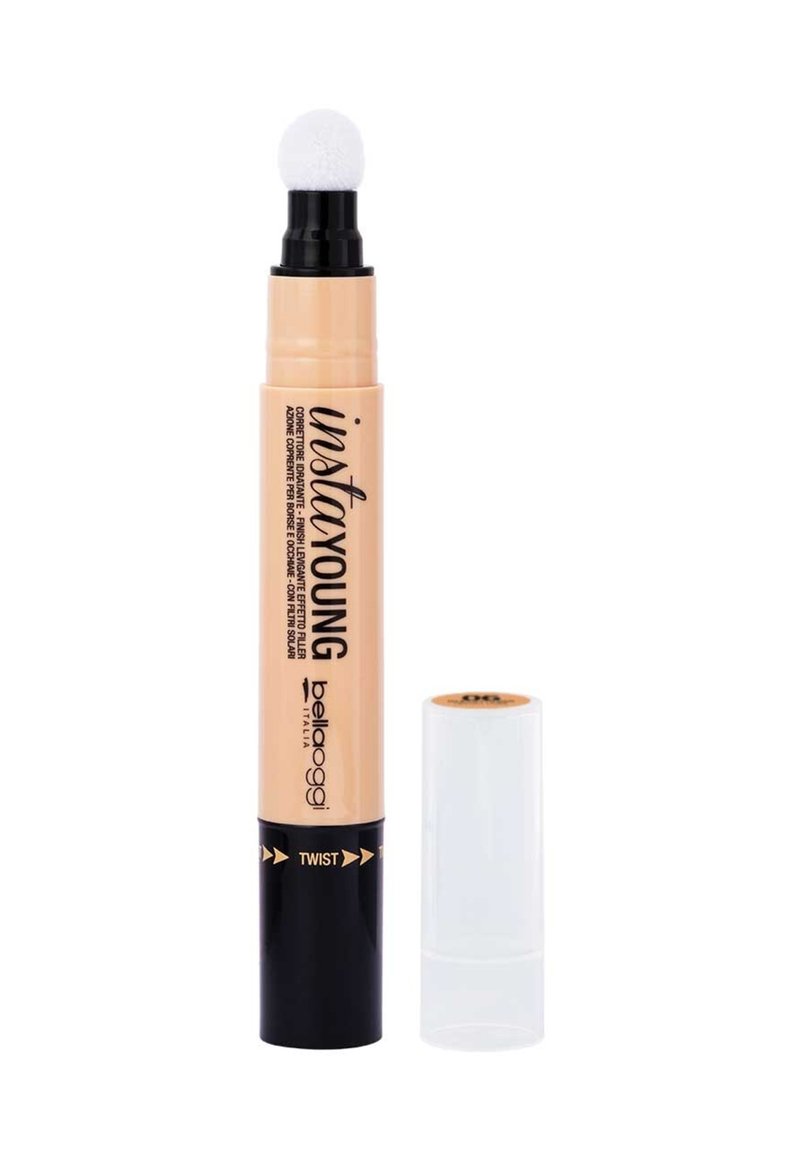 Penna correttore beige con un applicatore in schiuma bianca e un meccanismo a twist. Base nera con accenti dorati e cappuccio protettivo trasparente.