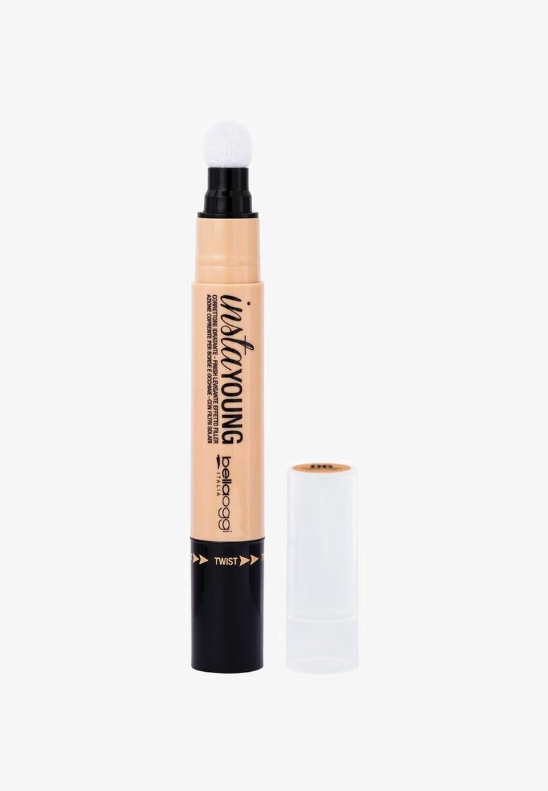 Penna correttore beige con un applicatore in schiuma bianca e un meccanismo a twist. Base nera con accenti dorati e cappuccio protettivo trasparente.