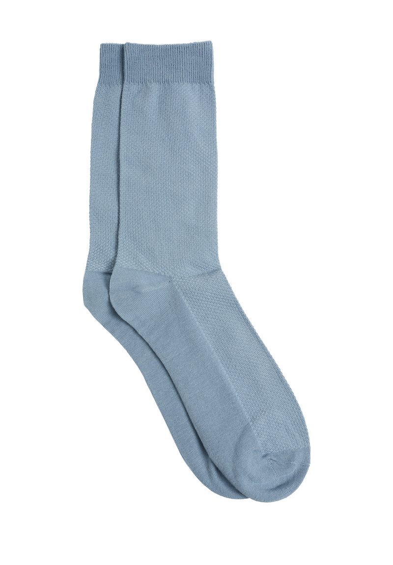 Svjetloplave pamučne čarape s glatkom teksturom, rebrastim rubom i jednostavnim dizajnom. Sadrži bešavne zatvaranje nožnog prsta za udobnost.