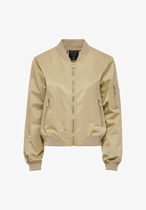 Jasno beżowa kurtka bombowiec o gładkim, błyszczącym wykończeniu. Posiada zamek z przodu, ściągacze przy mankietach, dwie boczne kieszenie oraz kieszeń na zamek na rękawie.