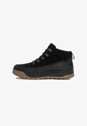 Stivaletti mid-top in suede e pelle nera con accenti grigi, occhielli in metallo per i lacci e suola in gomma color tan. Presentano un'etichetta sul retro.