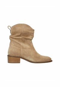 Stivaletto in suede color beige con design morbido, punta rotonda e tacco in legno basso. Presenta una linguetta sul retro per una facile calzata.