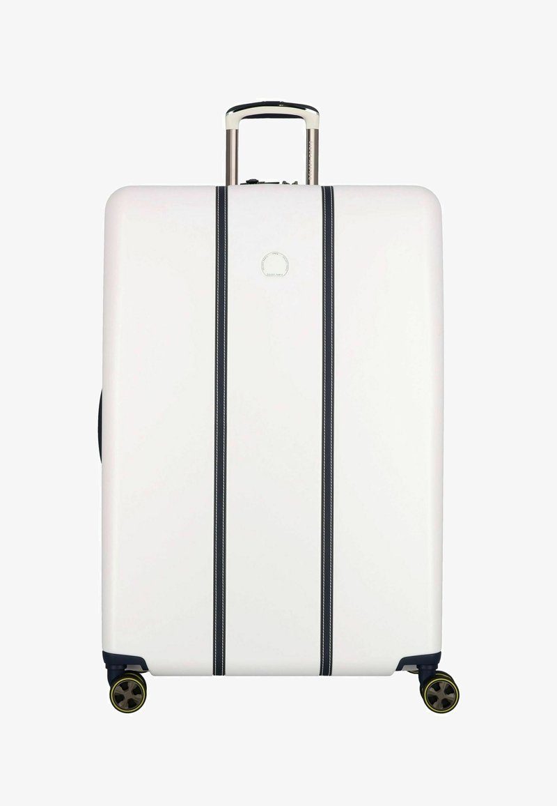 Valigia rigida bianca con strisce verticali nere, manico retrattile e quattro ruote. Presenta un logo sulla parte frontale. Texture liscia.
