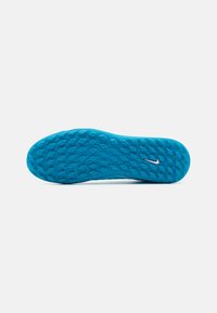 Nike kinga taldaga heledas sinises värvuses, millel on tekstureeritud, laineline muster ja väike valge swoosh logo. Kuju on ümar, tugeva kandiga.