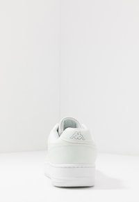 Weißer Sneaker mit einem glatten synthetischen Obermaterial, gepolstertem Kragen und strukturiertem Gummisohle. Verfügt über ein dezentes Logo an der Ferse.