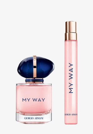 Botella de perfume de vidrio con un líquido rosa, tapa azul marino, detalles dorados, etiquetada como "MY WAY" y un aplicador de tamaño de viaje a juego.
