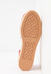 Semelle en caoutchouc avec texture à motifs, couleur beige clair et design gaufré ; taille 37. Le bord présente un dessus tissé coloré.