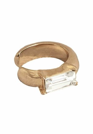 Gold-tone ring with a smooth, rounded band and a rectangular clear stone set at the front. The stone has sharp angles and a faceted surface.